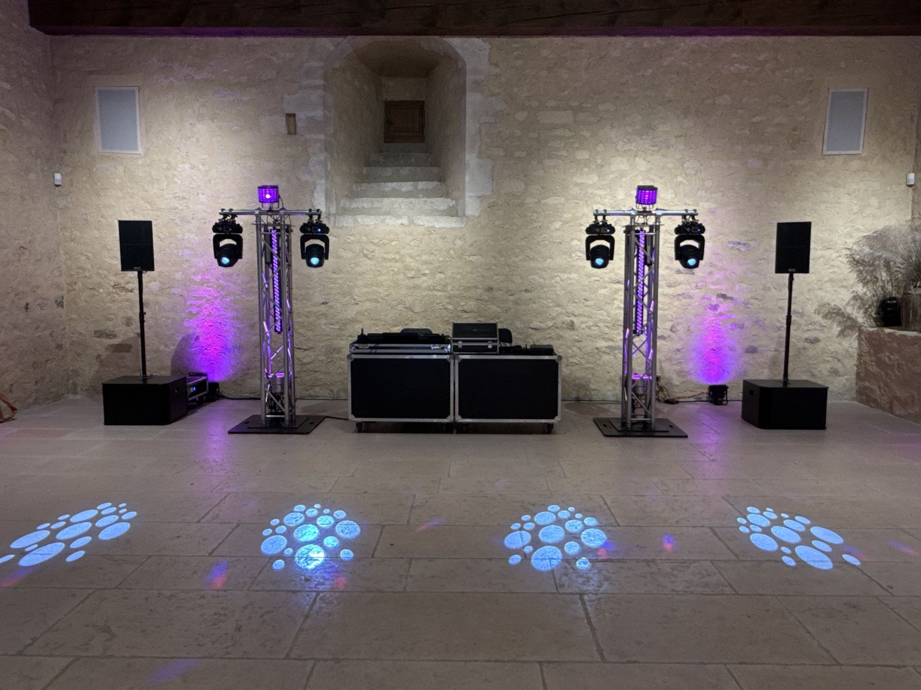 Installation son et lumière dans une salle en pierre avant l'arrivée des invités