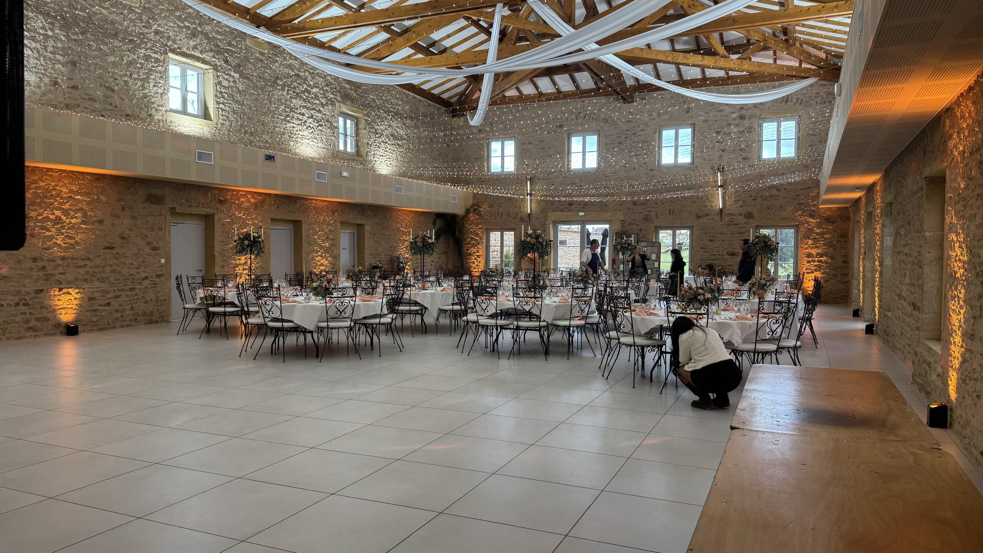 Salle de réception en pierre dressée pour un mariage, éclairage ambré