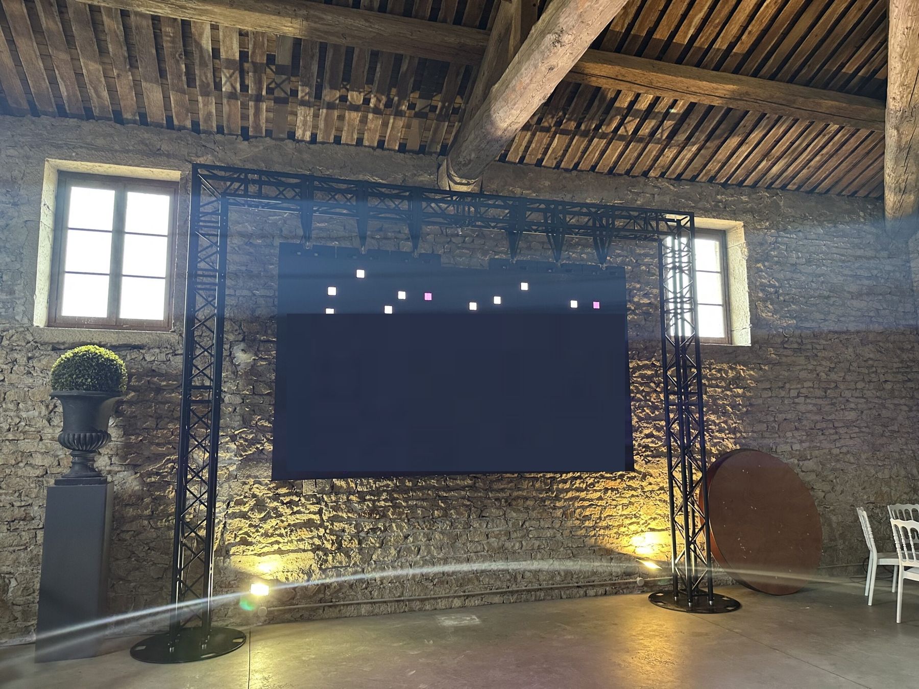 Écran LED sur structure dans une salle en pierre